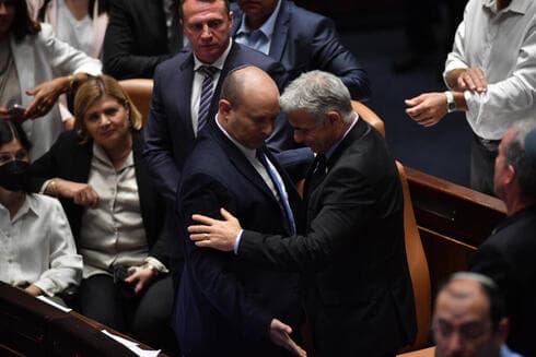 Bennett intercambia asientos con Lapid tras la votación que disolvió la 24° Knesset de Israel. (Yoav Davidkovich) Bennett Lapid Knesset