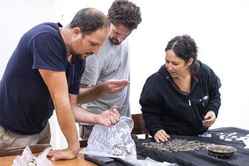 Inspectores de la Autoridad de Antigüedades de Israel examinan los hallazgos descubiertos en la casa del sospechoso. (Yuli Schwartz) Inspectores de la Autoridad de Antigüedades de Israel examinan los hallazgos descubiertos en la casa del sospechoso.