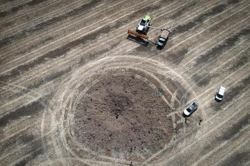 Un agricultor recoge la cosecha en un campo alrededor de un cráter dejado por un cohete ruso a diez kilómetros de la línea del frente en la región de Dnipropetrovsk, Ucrania, el 4 de julio de 2022. (AP) Un agricultor recoge la cosecha en un campo alrededor de un cráter dejado por un cohete ruso a diez kilómetros de la línea del frente en la región de Dnipropetrovsk, Ucrania, el 4 de julio de 2022.