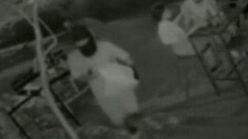Un hombre enmascarado se acerca al pub con una bolsa blanca. 