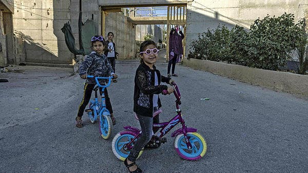 Los niños de la familia palestina Gharib con una de las barreras de fondo. (Menahem Kahana/AFP) Los niños de la familia palestina Gharib con una de las barreras de fondo.