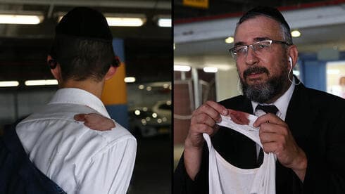 El padre del sobreviviente sostiene la camisa rasgada por una de las balas. (Alex Kolomoisky) El padre del sobreviviente sostiene la camisa rasgada por una de las balas.