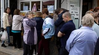 Refugiados forman una fila para recibir alimentos en Umán. 