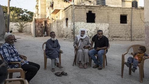 El trabajador palestino Ibrahim Slaieh compare con sus vecinos en su día libre de trabajo en Israel, frente a su casa de Khan Younis, al sur de la Franja de Gaza. (AP) El trabajador palestino Ibrahim Slaieh