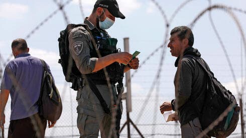 Un oficial de la Policía de Fronteras verifica los documentos de un palestino en el cruce de Jenin. 