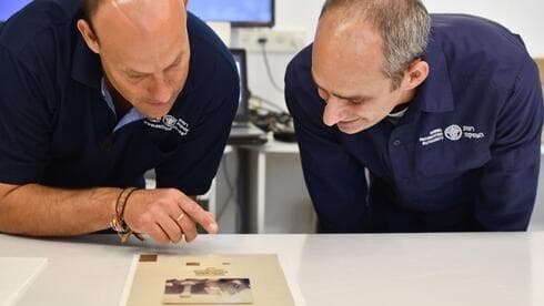 Investigadores examinan el papiro. 