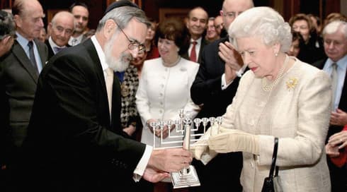 El difunto gran rabino británico Jonathan Sacks le da a la reina una menorá en una recepción en el Palacio de St. James en Londres para conmemorar el 350 aniversario del restablecimiento de la comunidad judía en Gran Bretaña, el 28 de noviembre de 2006 (Foto: Biblioteca de imágenes Tim Graham/ Getty images) El difunto gran rabino británico Jonathan Sacks le da a la reina una menorá en una recepción en el Palacio de St. James en Londres para conmemorar el 350 aniversario del restablecimiento de la comunidad judía en Gran Bretaña, el 28 de noviembre de 2006