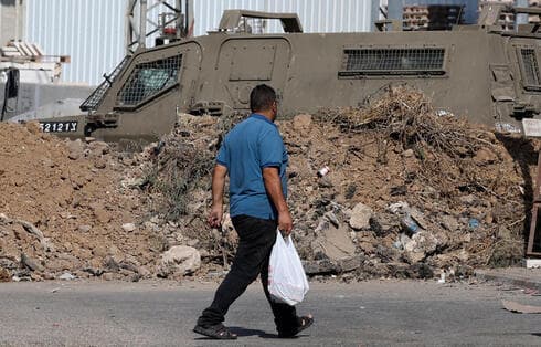 Un hombre camina junto a un vehículo blindado de las FDI después de que Israel bloqueara las entradas a Naplusa (Foto: AFP) Un hombre camina junto a un vehículo blindado de las FDI después de que Israel bloqueara las entradas a Naplusa