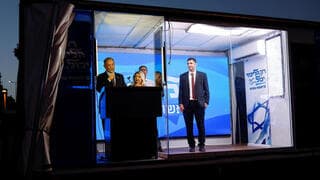 Netanyahu habla desde su autobús de campaña, detrás de un vidrio blindado. 