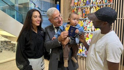 El embajador Hayek alza al primer niño nacido en Emiratos Árabes Unidos que recibe un pasaporte israelí. (Ynet) Pasaporte Israel Emiratos