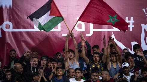 Banderas marroquíes y palestinas que se agitan mientras los palestinos observan el partido entre Marruecos y Porrugal. (AP) Banderas marroquíes y palestinas que se agitan mientras los palestinos observan el partido entre Marruecos y Porrugal.