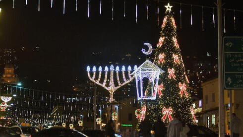 Un árbol de Navidad junto a un candelabro de Janucá en Haifa, Israel.