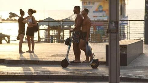 Jóvenes se transportan en scooter por las calles de Tel Aviv.