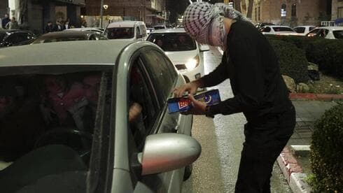 Palestinos reparten dulces en celebración por los siete israelíes asesinados en Jerusalem. (AFP) Palestinos reparten dulces en celebración por los siete israelíes asesinados en Jerusalem.