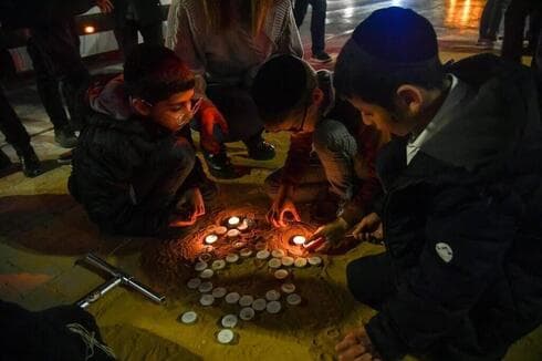 Civiles encienden velas en el lugar del mortal tiroteo terrorista en el barrio Neve Yaakov de Jerusalem, el mes pasado. (Yoav Dudkevitch) Civiles encienden velas en el lugar del mortal tiroteo terrorista en el barrio Neve Yaakov de Jerusalem, el mes pasado.