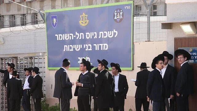 Hombres ultraortodoxos ante un centro de reclutamiento en el centro de Israel. (Moti Kimchi) Hombres ultraortodoxos ante un centro de reclutamiento en el centro de Israel.