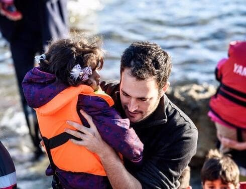 Yotam Polizer rescata a un niño refugiado sirio en Lesbos (Grecia).