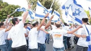 Jóvenes agitan banderas israelíes en Jaffa. 