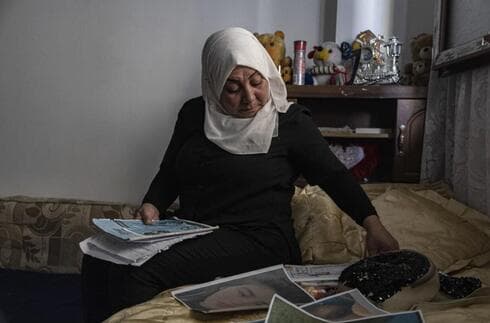 Hamrin Alouji, madre de Peyal Aqil, de 13 años, revisa las fotografías de su hija en su casa familiar de Qamishli, Siria. (AP) Hamrin Alouji, madre de Peyal Aqil, de 13 años, revisa las fotografías de su hija en su casa familiar de Qamishli, Siria.