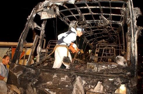Rescatista examina los restos carbonizados de un autobús volado en un atentado suicida durante la Segunda Intifada. (Elad Gershgorn) Rescatista examina los restos carbonizados de un autobús volado en un atentado suicida durante la Segunda Intifada.