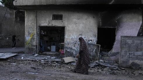 Una mujer palestina camina junto a las casas destruidas en la ofensiva de las FDI en el campo de refugiados de Jenín. (AP) Una mujer palestina camina junto a las casas destruidas en la ofensiva de las FDI en el campo de refugiados de Jenín.
