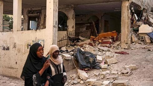 Mujeres caminan junto a las casas destruidas en el campo de refugiados de Jenín. (AFP) Mujeres caminan junto a las casas destruidas en el campo de refugiados de Jenín.