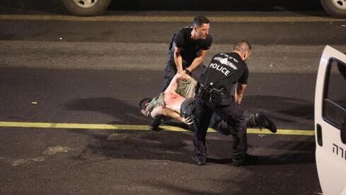 Dos policías retiran con violencia a un manifestante que se negaba a desalojar la autopista. 