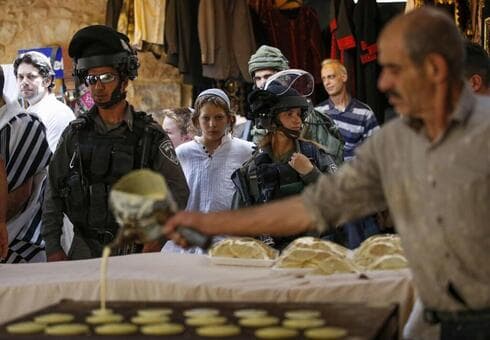 Tropas israelíes marchan por el mercado de Hebrón.