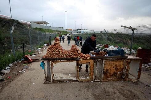 Comerciante palestino vendiendo rosquillas a los palestinos que cruzan para trabajar en Israel. (Reuters) Comerciante palestino vendiendo rosquillas a los palestinos que cruzan para trabajar en Israel.