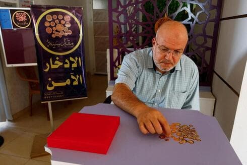 Ahmed Hamdan ofrece monedas de oro a residentes de bajos ingresos de la Franja de Gaza. (Reuters) Ahmed Hamdan ofrece monedas de oro a residentes de bajos ingresos de la Franja de Gaza.