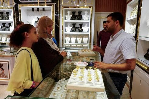 Vendedor de oro palestino vende pieza en una joyería de Khan Younis.