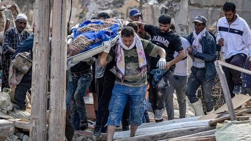 Aldeanos sacan cadáveres de entre los escombros en Marruecos.