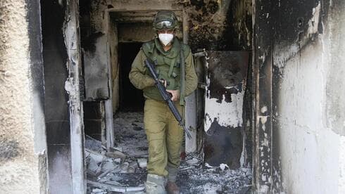 Un soldado sale de una casa incendiada en Kfar Aza. 