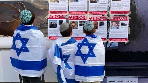 Niños israelíes frente a las fotos de los secuestrados por Hamás.