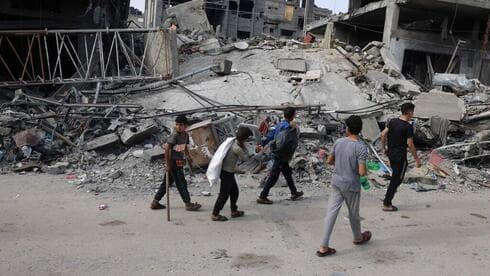 Niños caminan entre las ruinas de Gaza.