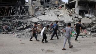 Niños caminan entre las ruinas de Gaza.