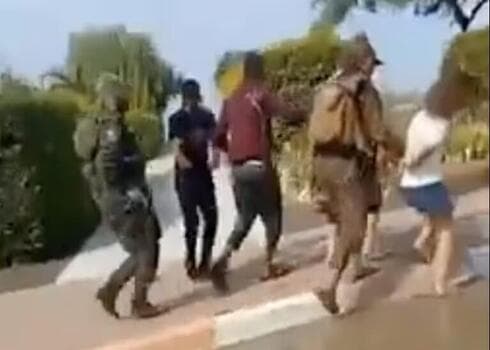 Militantes de Hamás trasladan a rehenes israelíes por una calle en Be'eri, un kibutz en el sur de Israel, según muestra un video publicado en X (Captura de pantalla) Militantes de Hamás trasladan a rehenes israelíes por una calle en Be'eri, un kibutz en el sur de Israel, según muestra un video publicado en X