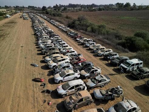 Coches de asistentes al festival alineados, muchos de ellos con daños por incendio 