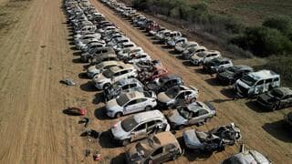 Coches de asistentes al festival alineados, muchos de ellos con daños por incendio 