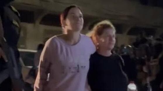 Dos de los rehenes liberados flanqueados por un terrorista de Hamás