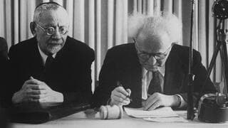 El primer primer ministro de Israel, David Ben Gurion, firma la Declaración de Independencia