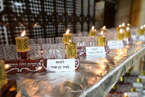 Se colocadon 138 menorás de Janucá en el auditorio de la ieshivá, correspondiente al número de rehenes, cada uno con el nombre de un rehén. (Yossi Zeliger) Estudiantes de Erlau Yeshiva encienden menorás de Hanukkah para los rehenes