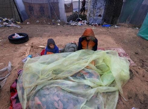 Niños palestinos se cubren con plástico de las intensas lluvias al sur de Gaza. (Reuters) Niños palestinos se cubren con plástico de las intensas lluvias al sur de Gaza.