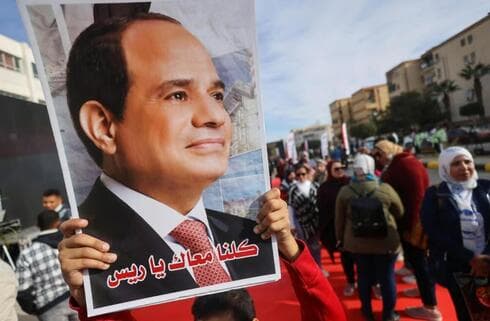 Un cartel de Sisi junto a uno de los colegios electorales. 