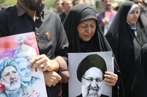 Iraníes con fotos de Raisi y de Qassem Soleimani. 