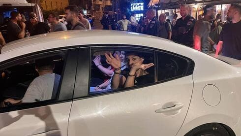 Noam Dan es esposada en un coche patrulla. 
