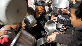 Palestinos se empujan para poder recibir alimentos en Jabaliya. 
