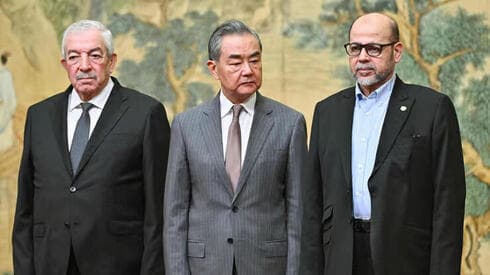 El acuerdo fue firmado en China. De derecha a izquierda: Musa Abu Marzouq, Wang Yi y Mohammed al-Aloul. 