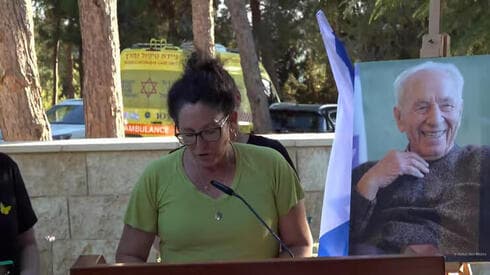 Liat Atzili durante su discurso. Detrás, la imagen de Shimon Peres. 