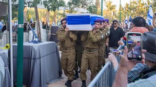 Sus camaradas y el hermano de Santiago acompañan los restos en el funeral. 